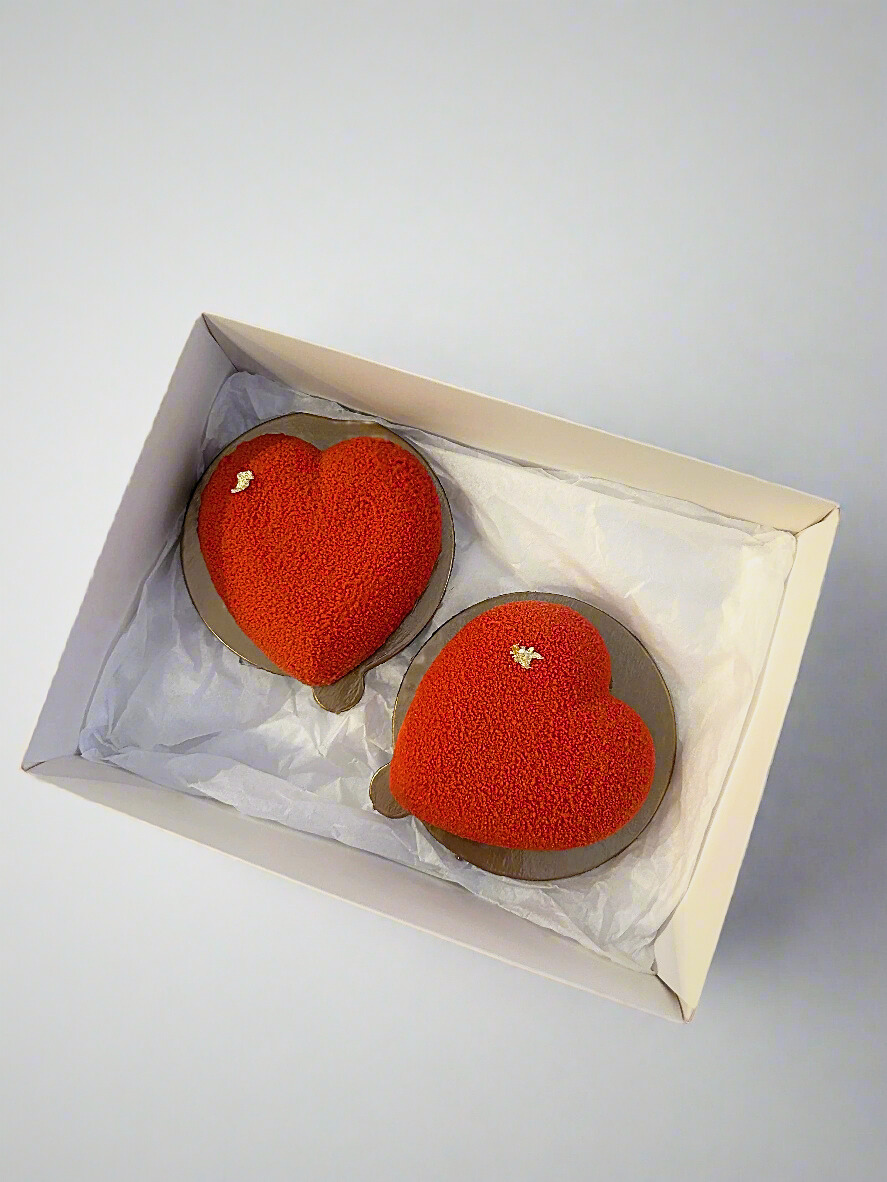 two mini heart shaped mousse dessert in white box