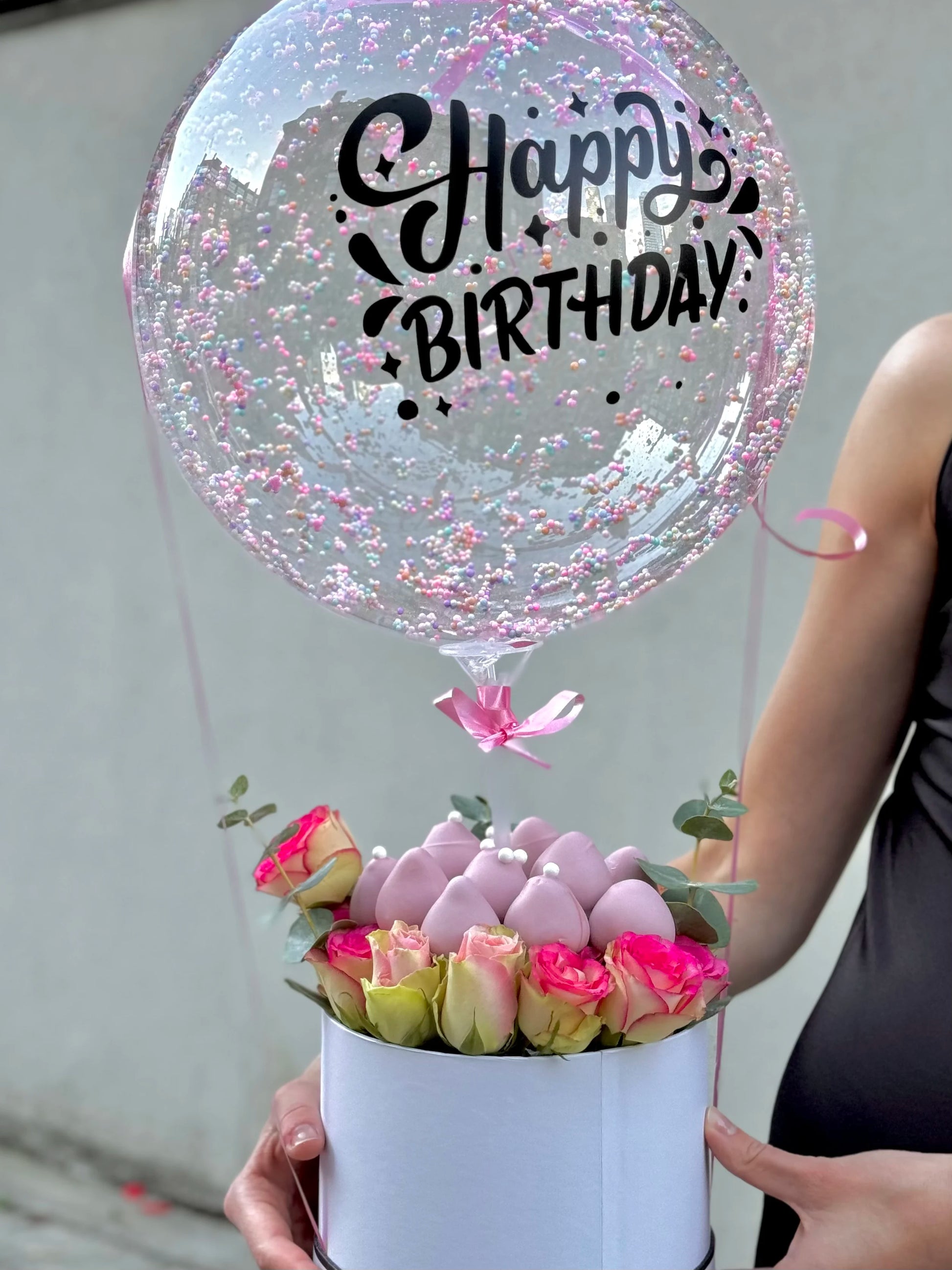 close up of bobo balloons with dipped strawberries and roses