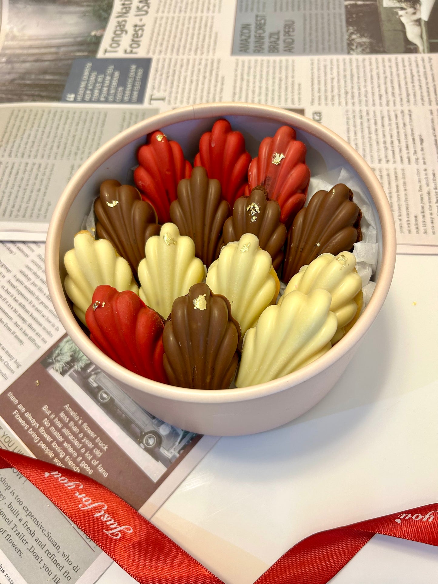 Madeleines in round box with ribbon 
on the background