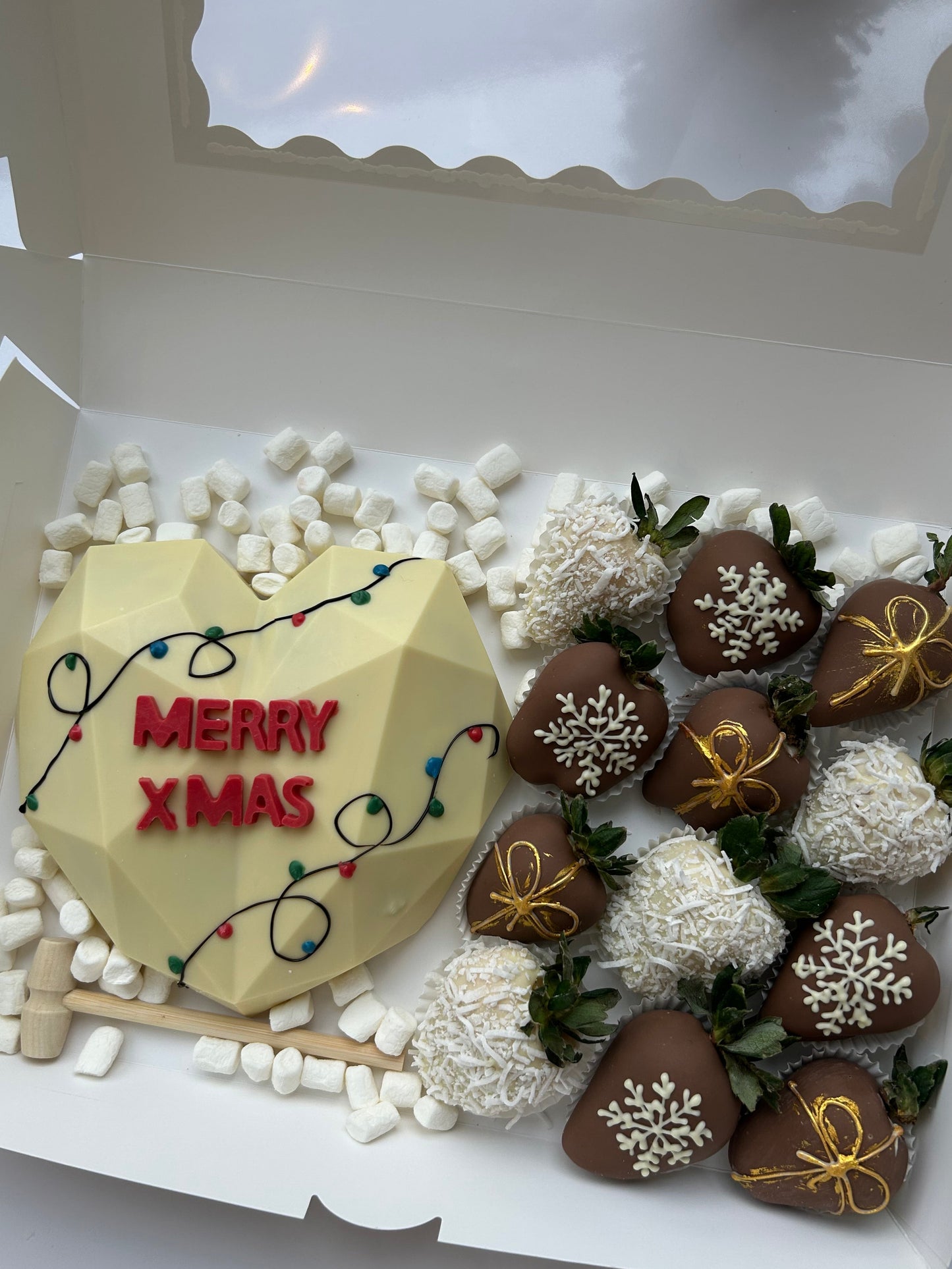 Decorative Christmas-themed cake with chocolate cookies and a 'Merry Xmas' sign.